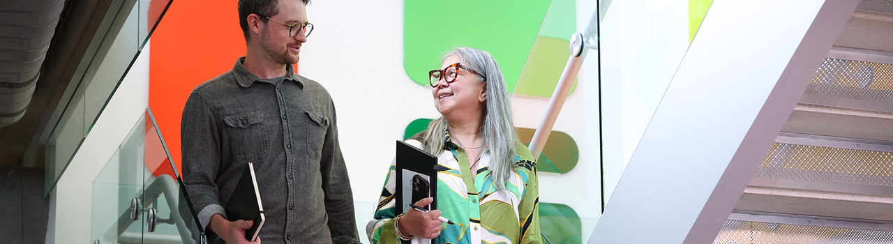 Two NYGC employees walk down stairs at the NYGC facility