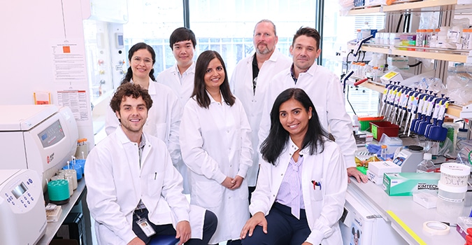 Seven scientists in a lab pose for a team photo