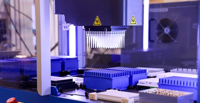 Close up of a machine that fills a tray of vials all at once