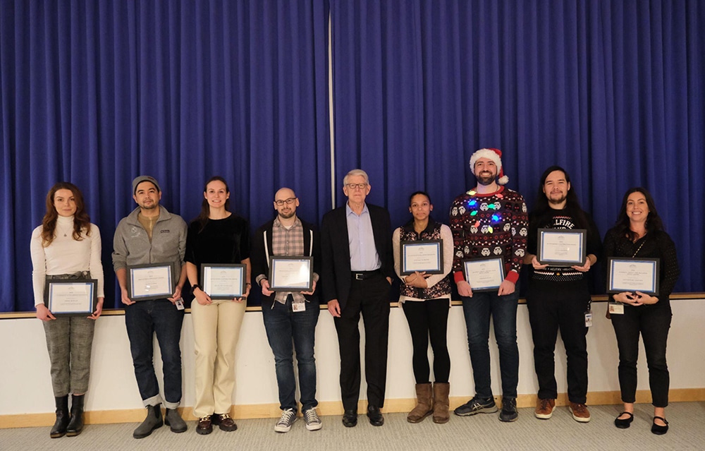 A group of NYGC employees display awards